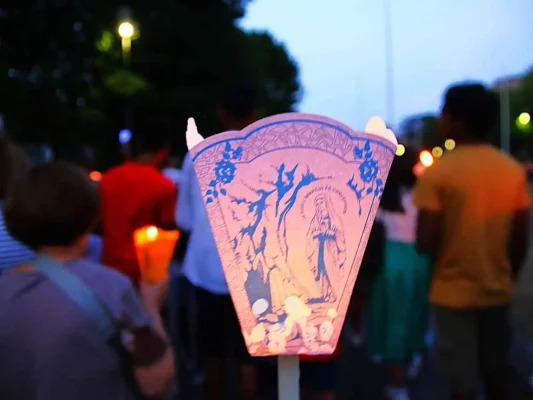 Processione serale dei pellegrinaggi a Lourdes con le fiaccole. Pellegrinaggio a Lourdes Tu sei Pietro Viaggi.