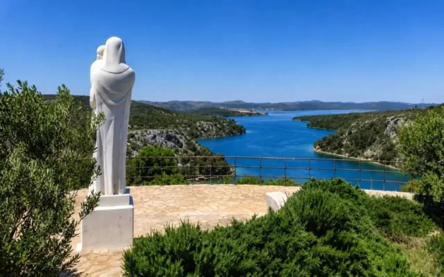 statua della Madonna con Bambino davanti a un fiordo in Croazia
