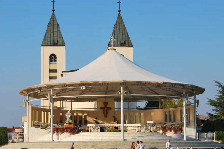 Altare esterno con copertura bianca davanti ai campanili della chiesa di San Giacomo a Medjugorje