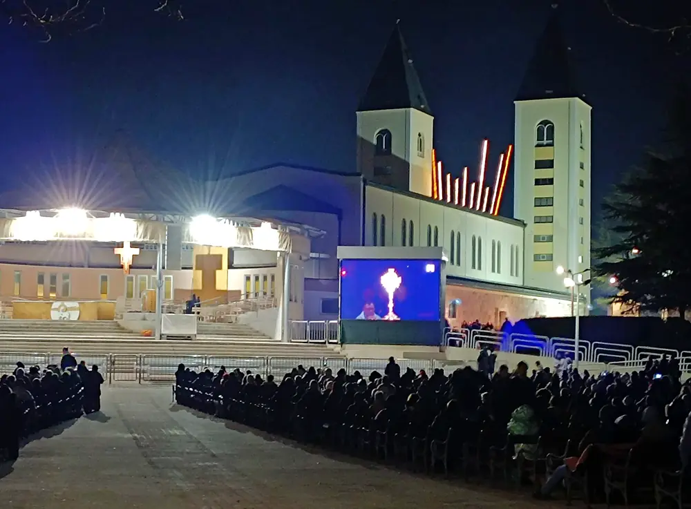 Adorazione eucaristica notturna all'altare esterno di Medjugorje durante il pellegrinaggio di Capodanno