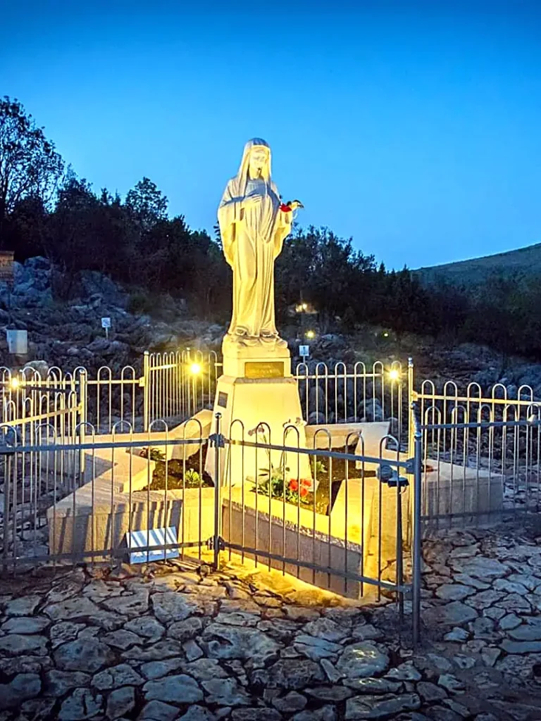 Statua della Madonna illuminata di sera sul Colle delle Apparizioni a Medjugorje